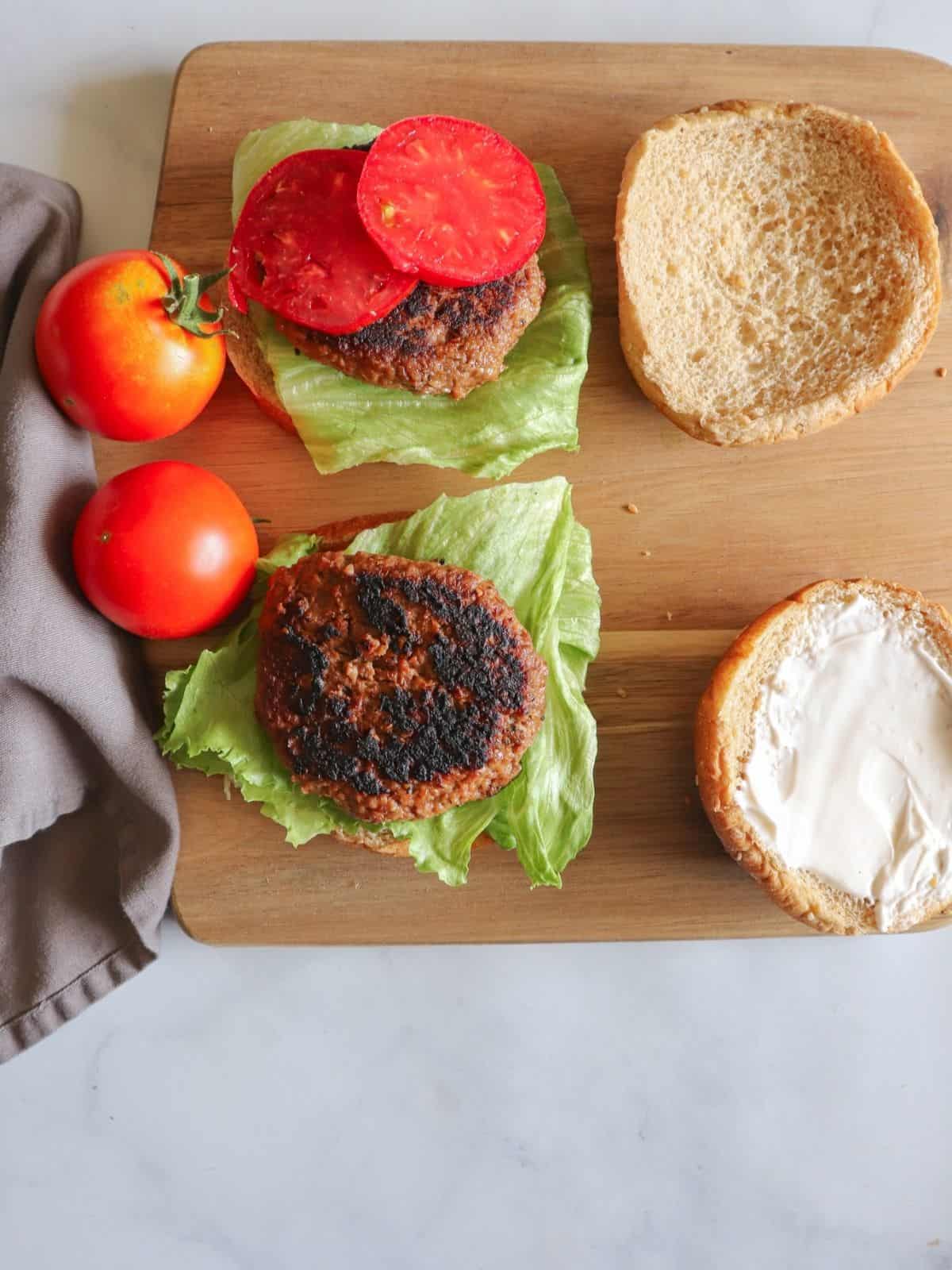 buns, tomatoes and lettuce on wooden surface
