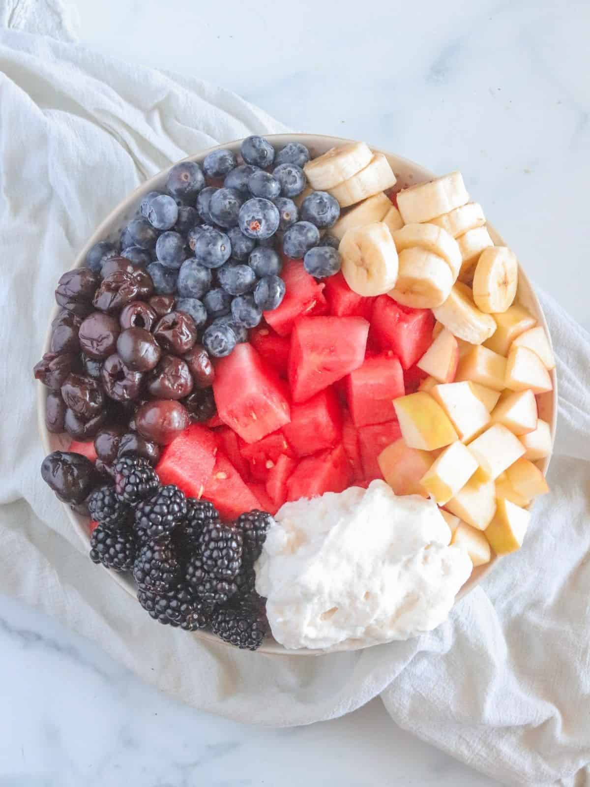 diced watermelon, bananas and berries in bowl