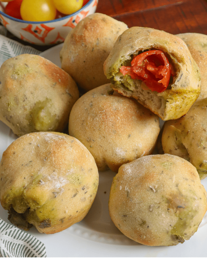 Balls of dough on white plate with tomatoes