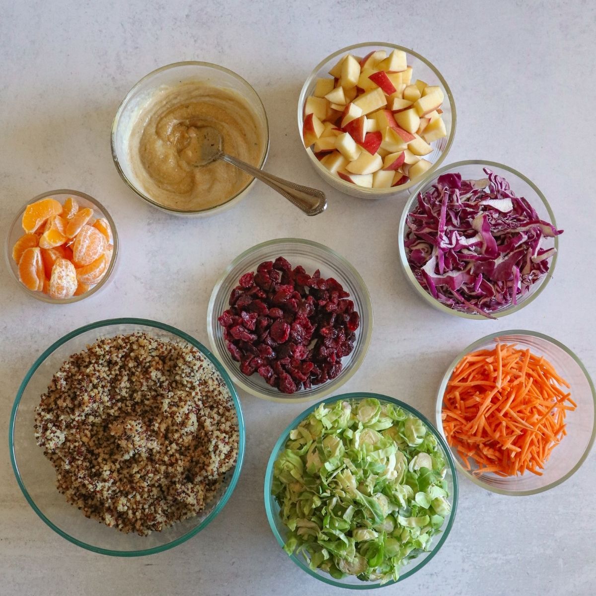 Quinoa, mandarins, tahini dressing, apples, red cabbage, carrots, Brussels sprouts, dried cranberries