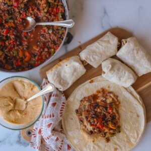 tortillas with vegan beef filling, multicolored napkin and marble background