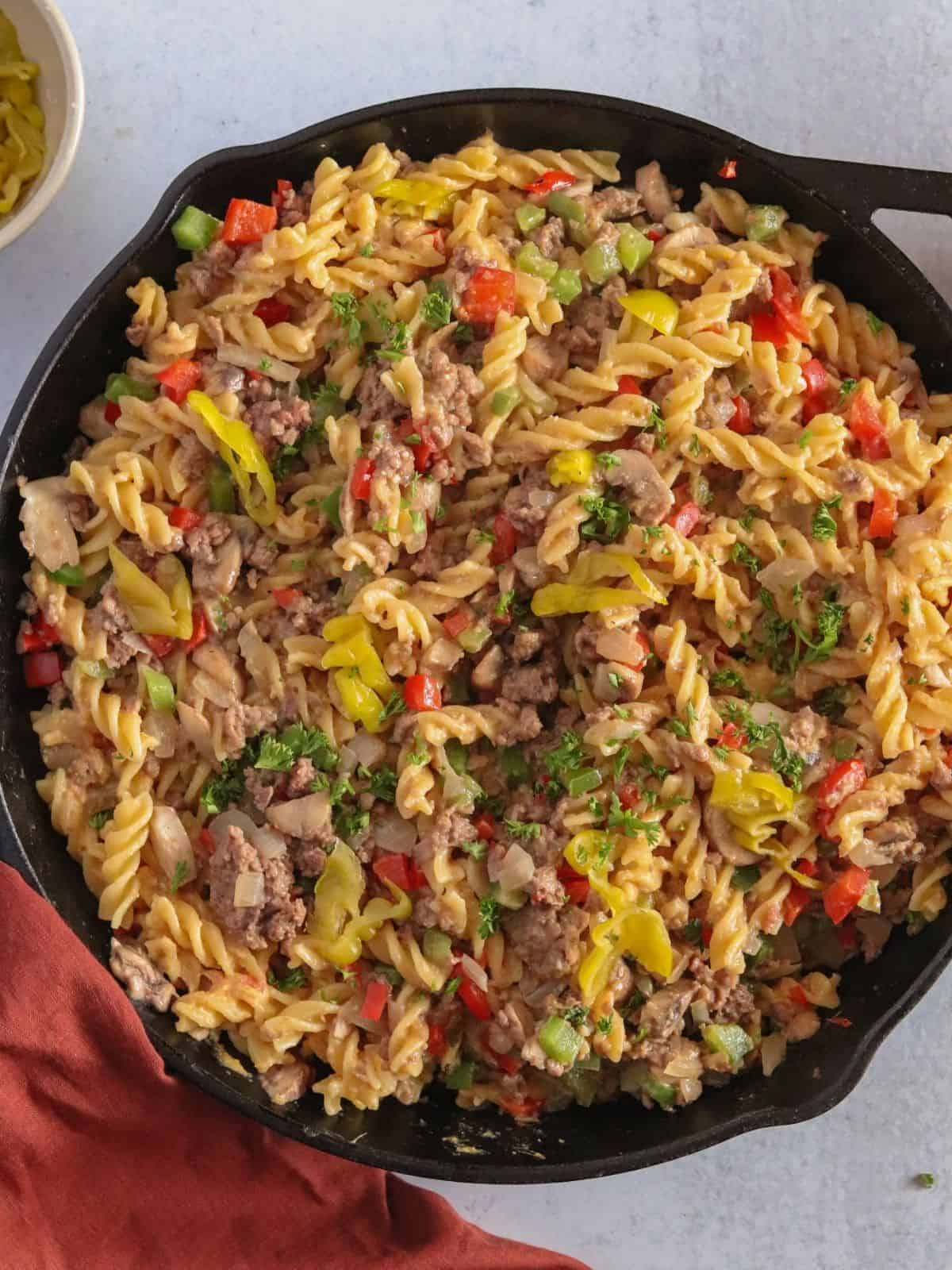 Noodles and beef in cast iron skillet with red napkin