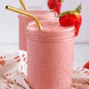 mason jar with golden straw and strawberry wedge