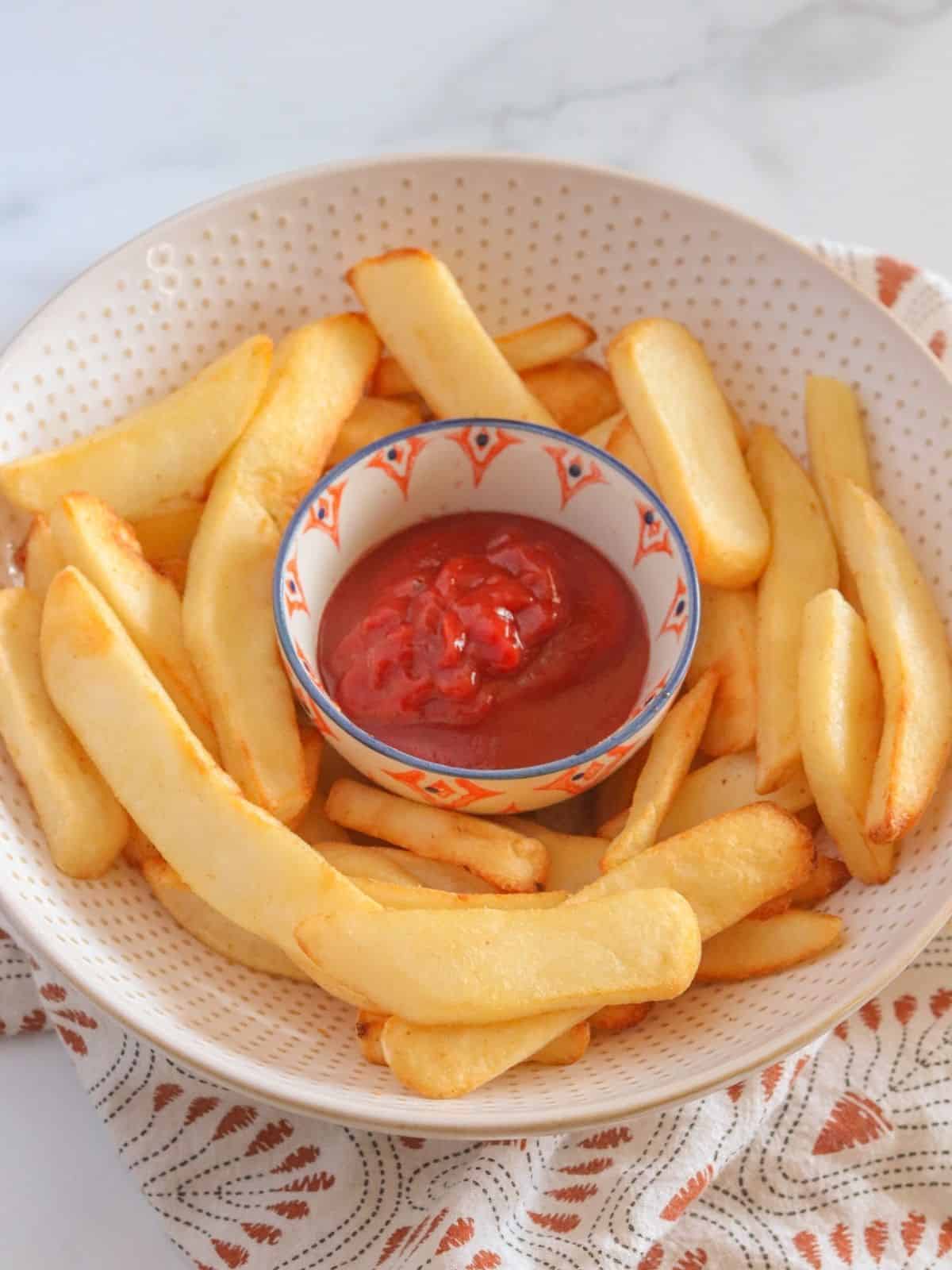 close up shot of potatoes and ketchup in bowl