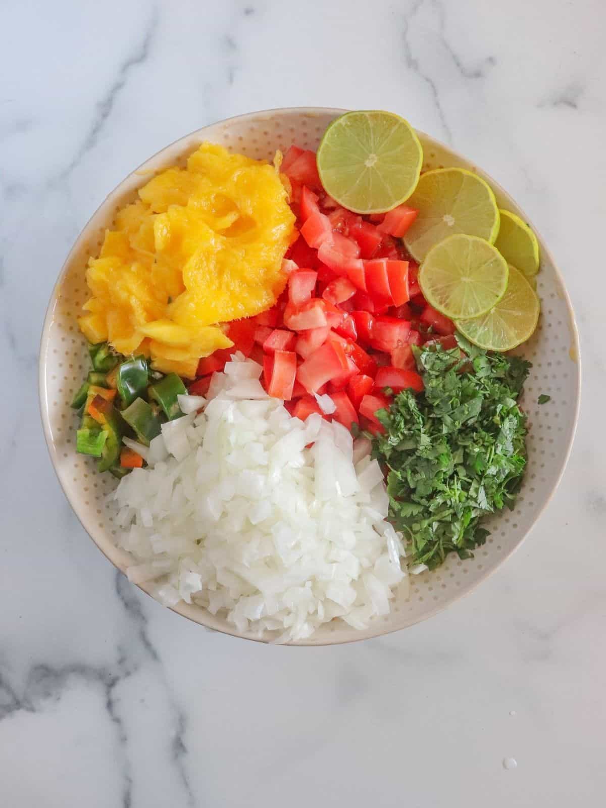 Bowl with diced vegetables, limes, onion and cilantro