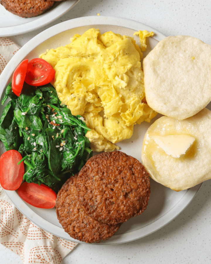 white plate with eggs and biscuits